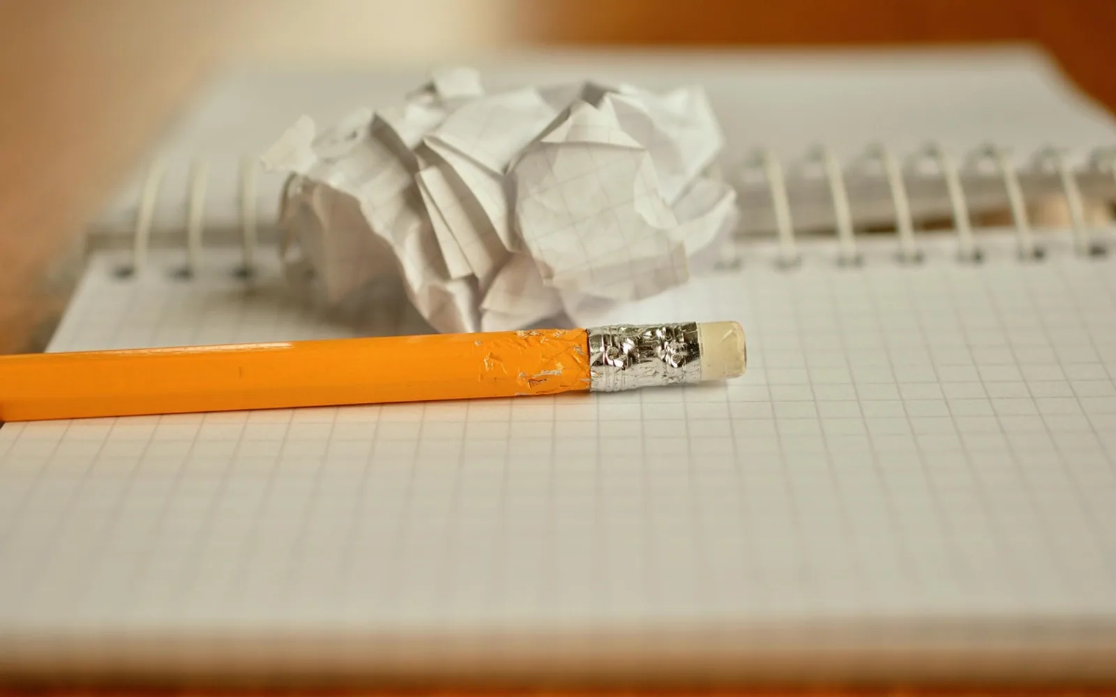 Pencil, notebook and crumpled